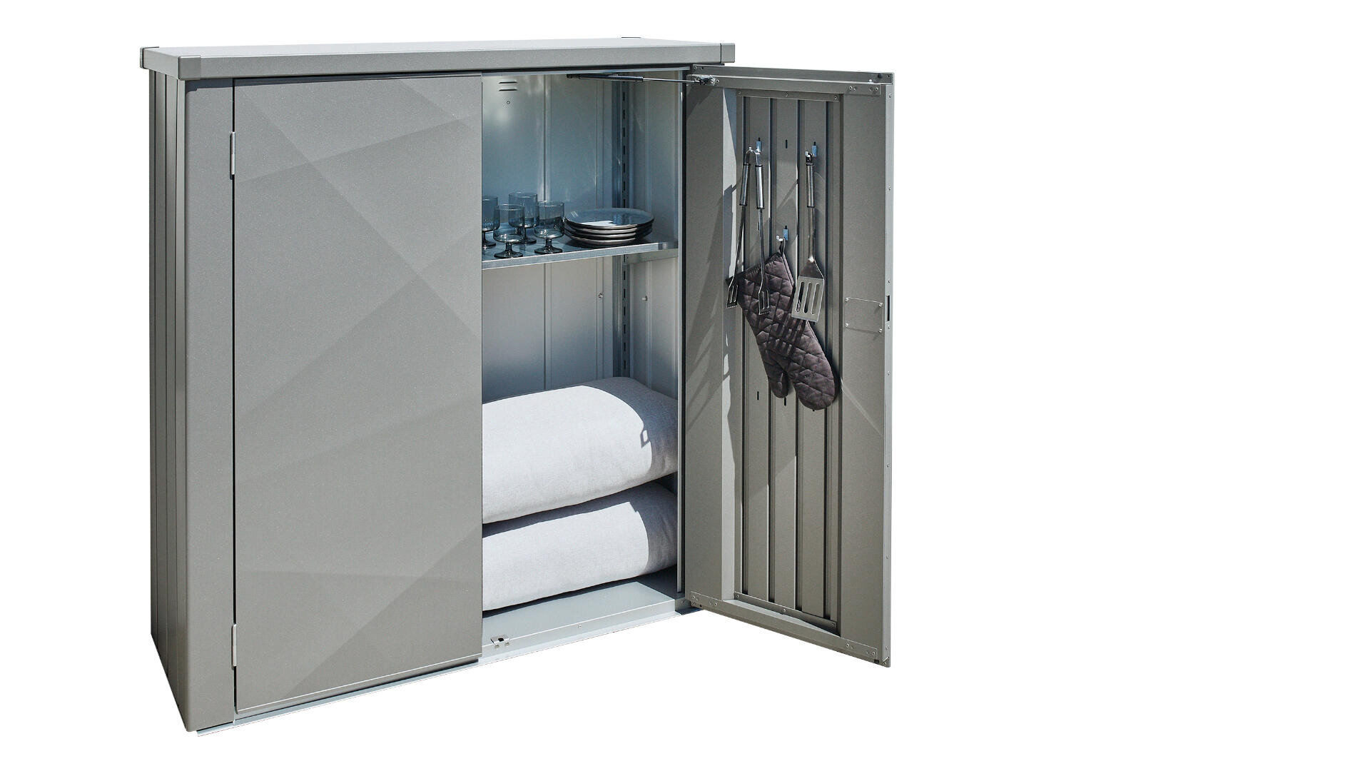 Ein grauer Metallschrank mit einer geöffneten Tür, die Regale mit Gläsern, Tellern, gefalteten Handtüchern und Haken an der Tür für Ofenhandschuhe zeigt. Der Hintergrund ist weiß.