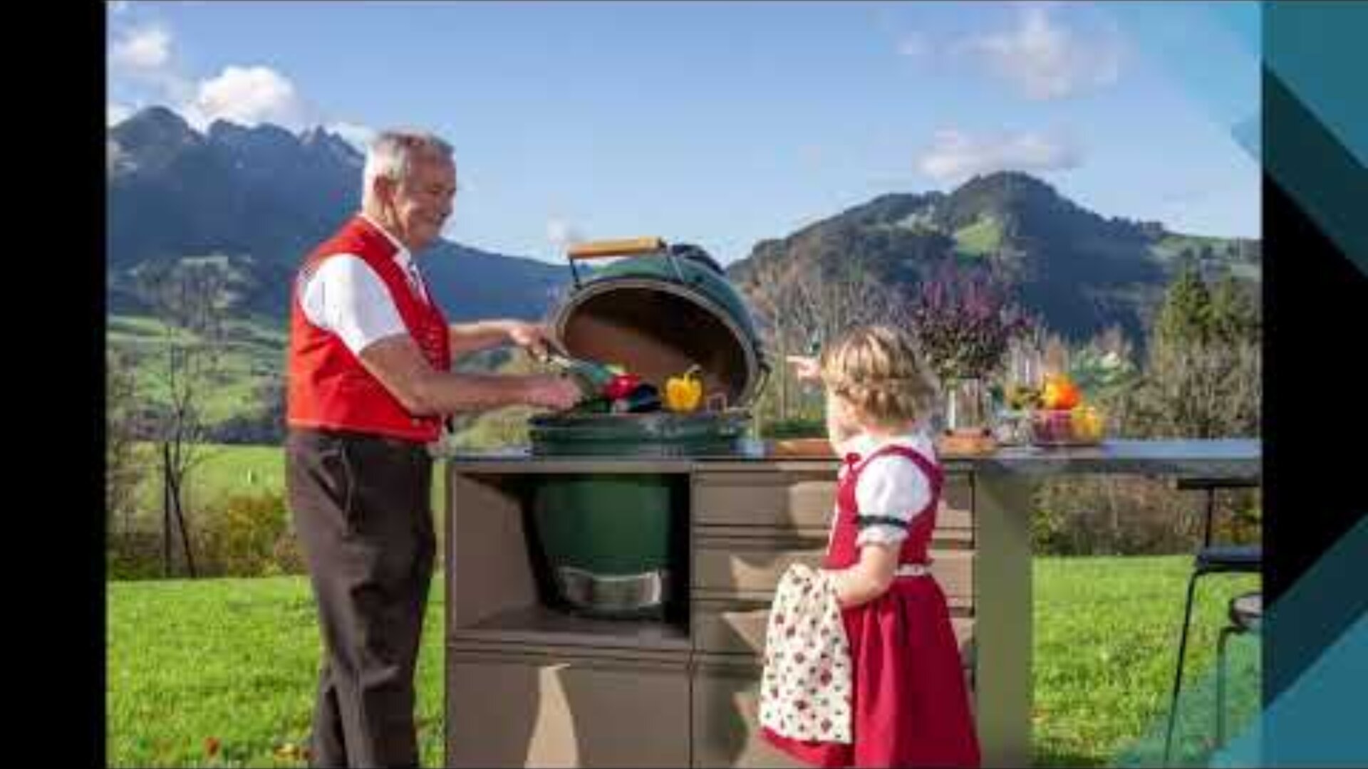 Ein älterer Mann und ein junges Mädchen, beide in traditioneller rot-weißer Kleidung, bereiten an einem Grill im Freien mit Bergen und grünen Hügeln im Hintergrund Essen zu. Das Mädchen hält ein kleines Handtuch und zeigt auf den Grill.